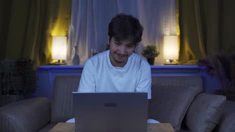 Hombre-Riendo-Usando-Una-Computadora-Portátil-Por-La-Noche.